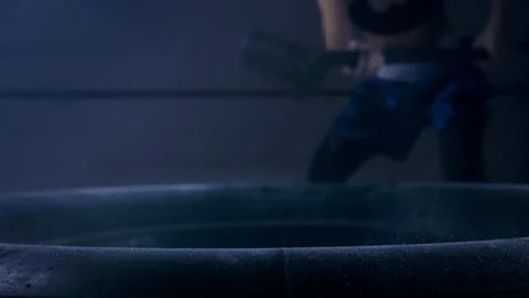 With powerful strokes, he performs a hammering exercise hitting the tire  Stock Footage 271556502