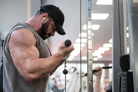 Powerful strong active guy with beard lifting heavy weight in gym listen musi 스톡 사진