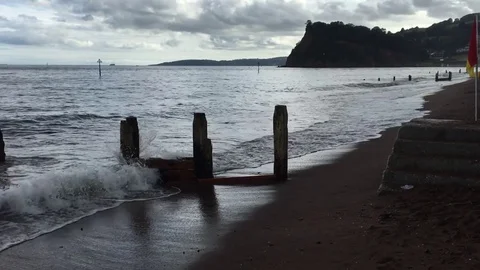 Powerful surging waves wash up the beach under an overcast cloudy sky Stock-Footage 72176422