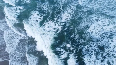 A powerful top-down aerial view of ocean waves crashing on a beach, Ocean Pow 스톡 동영상 317202248