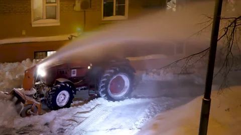 Powerful tractor clears heavy snow at night for winter maintenance operations Stock Footage 331506135