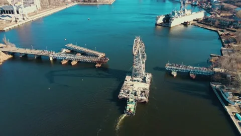 Powerful tugboat pulling floating crane by river in city of shipbuilders Stock Footage 188089761