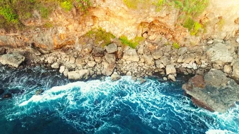 Powerful turquoise waves crash against rugged coastal rocks in a dramatic a.. Stock Footage 341547602