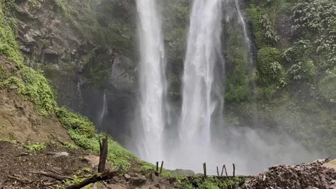 Powerful Twin Waterfalls Cascading Down Cliff, Lush Jungle, Upward Pan Shot Stock Footage 324498143