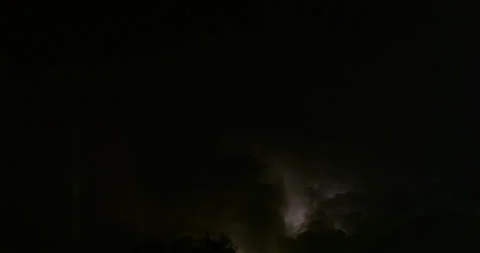 Powerful upward-moving lightning illuminate distant yet massive storm clouds. 스톡 동영상 320334181