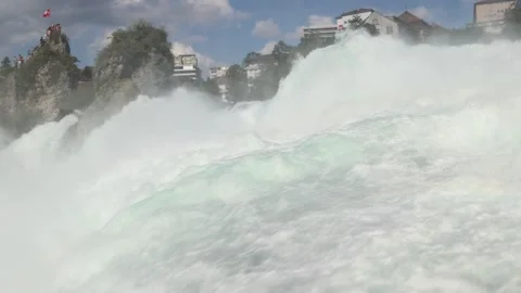 Powerful water current flowing over Rhine fall waterfalls, largest waterfall in Video stock 319483199