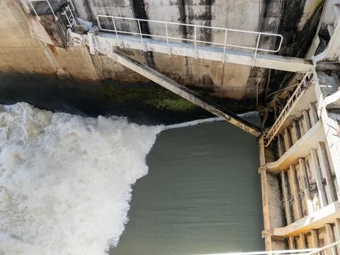 Powerful water discharge through the dam gate. Stock Photos