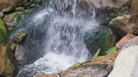 Powerful water flowing over mossy rocks at waterfall Stockbeeldmateriaal 340665883