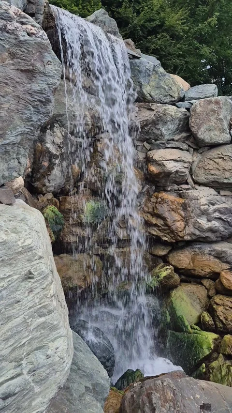 Powerful water flowing over mossy rocks at waterfall 動画素材 341755043