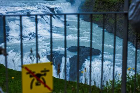 Powerful Waterfall Behind Safety Railing in Iceland Photos