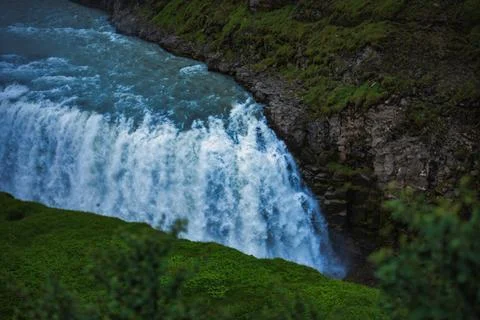 Powerful Waterfall Cascade in Moss-Covered Icelandic Landscape Фото