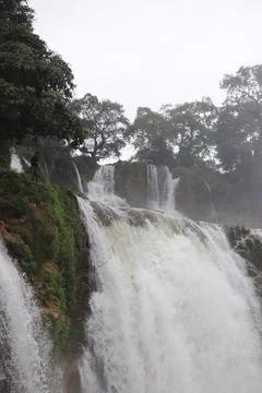 Powerful Waterfall Cascading Down a Lush Green Cliff Foto stock
