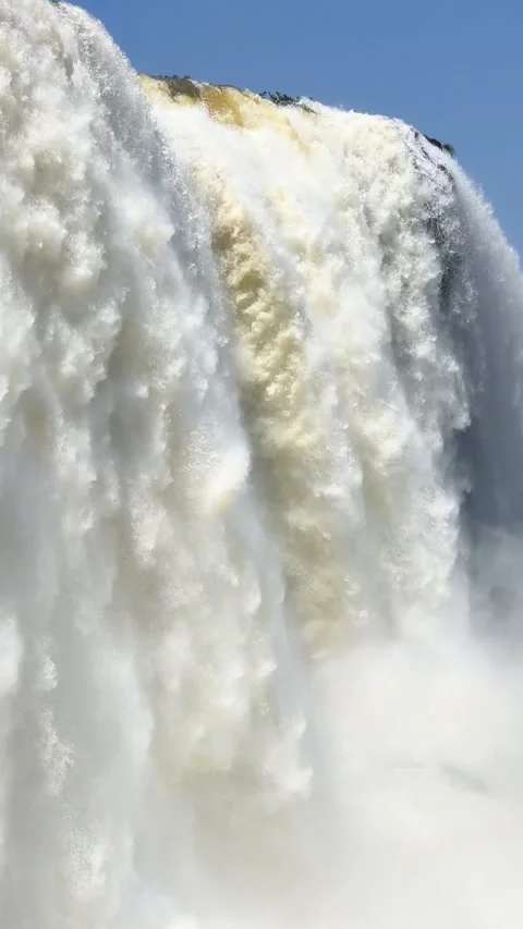 Powerful waterfall cascading down with mist under a clear blue sky. Stock Footage 276618583