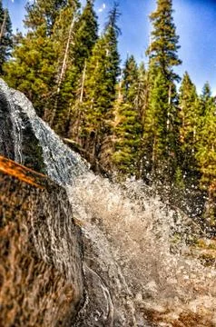 Powerful waterfall cascading down a mountain cliff Stock Photos