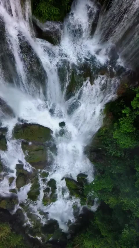 Powerful Waterfall Cascading Down Rocky Terrain in Lush Forest China Stock Footage 346335692