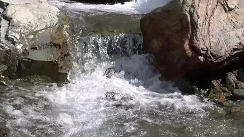 Powerful waterfall cascading over large rocks in pristine landscape Video stock 330317274