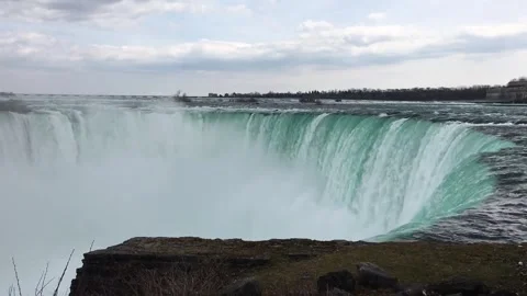 Powerful waterfall cascading over rocky edge with mist rising in Canada Stock Footage 310221543