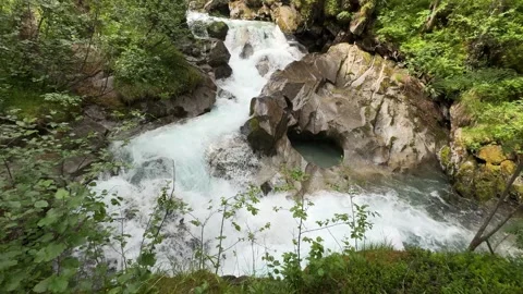 Powerful Waterfall Cascading Through Lush Green Forest in the Austrian Alps Stock Footage 332712426