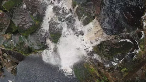 Powerful waterfall crashes over mossy, rugged rocks 스톡 동영상 342930122