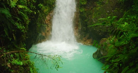 A powerful waterfall crashes into a vivid turquoise pool deep in Costa Rica Stock-Footage 326015130