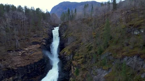 Powerful waterfall descending through rugged mountain terrain Stock-Footage 341327978