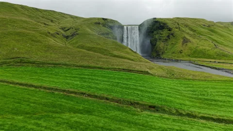 Powerful Waterfall Flowing Beyond Lush Green Hills Stock Footage 319702736