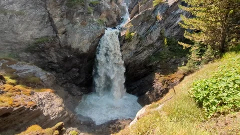 Powerful waterfall flowing through rocky mountain cliffs in alpine landscape Stock Footage 331503184