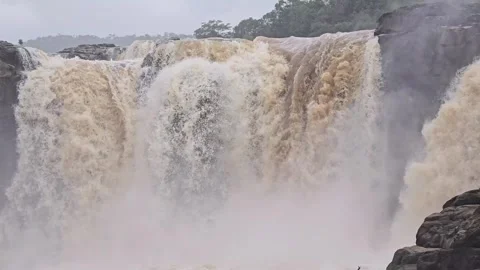 A powerful waterfall rushing over a rocky cliff during the monsoon season. Stock Footage 342047354