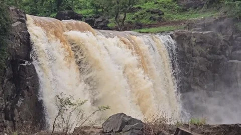 A powerful waterfall rushing over a rocky cliff during the monsoon season. Stock Footage 342047425