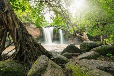 Powerful waterfall surrounded by trees and rocks Stock Photos