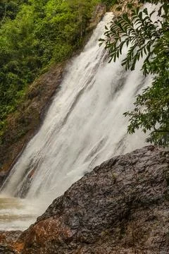 A powerful waterfall tumbling down from a steep rocky cliff surrounded by g.. Foto stock