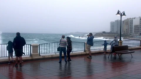 Powerful wave sprinkle the сrowd at Sliema embankment. Malta Stockbeeldmateriaal 89135287
