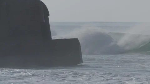 Powerful waves breaking  against World War Two bunker on a French beach Stock Footage 105307897