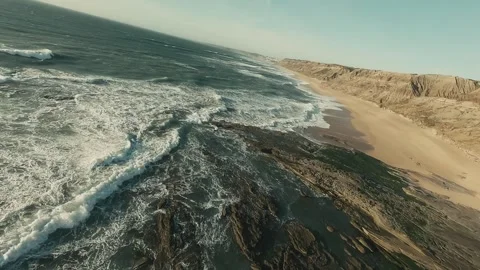 Powerful waves crash against rugged cliffs, swirling white foam Stock Footage 341827112