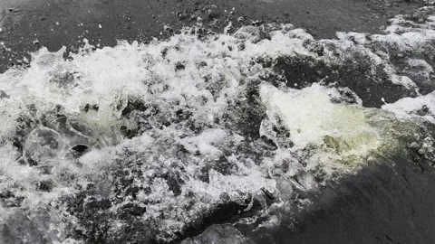 Powerful waves crash and churn in dramatic black and white motion, capturing raw Stock Footage 340503140