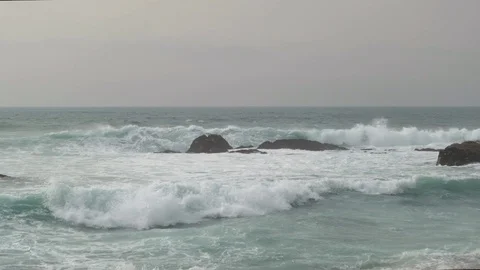 Powerful waves on ocean splashing against rocks in slow motion. 動画素材 127123199