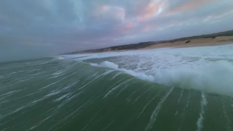 Powerful waves roll toward beach under dramatic sky Stock Footage 345148762