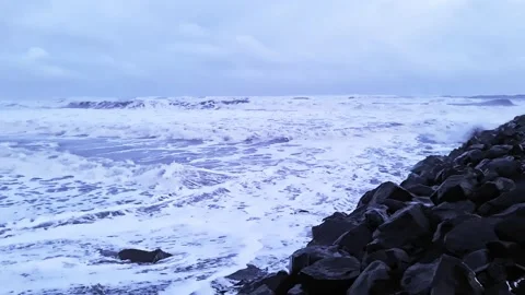 Powerful white foamy waves rolling and crashing against dramatic basalt rock Stock Footage 344606088