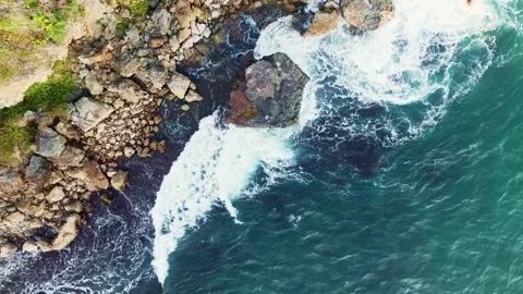 Powerful white waves crash against rugged rocks in a top-down aerial view o.. Stock Footage 341544255