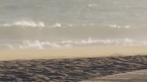 Powerful wind generating rippling patterns on sandy beach, blowing fine sand Stock Photos