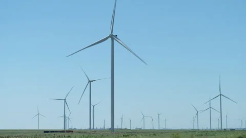 Powerful windmill farm generates electricity on green meadow Stock Footage 158164066
