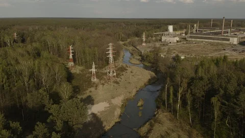 Powerlines in the forest over the river with factory in the background Stock-Footage 130076293