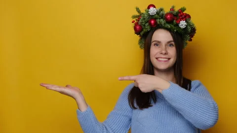 Pozitive young lady keeps palm raised, points with fore finger at free space Stock Footage 141068237