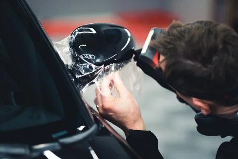 PPF wrapping process. Back view of unrecognizable professional mechanic applying Stock Photos