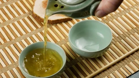 PPouring green tea into ceramic chawans from gaiwan.  Video stock 287601154