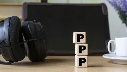 PPP -acronum on cubes on the background of the tablet, headphones and a white Stock Photos
