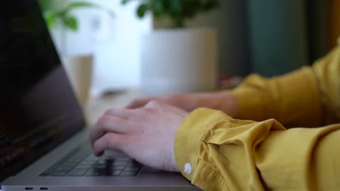 Pprogrammer in a yellow shirt typing code on the keyboard Stock Footage 142400854