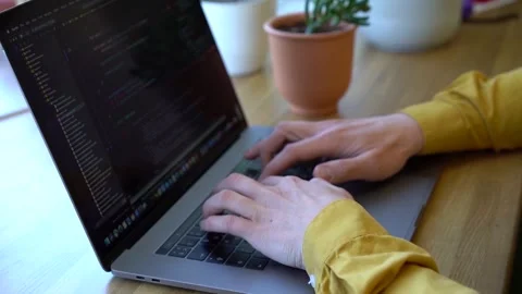 Pprogrammer in a yellow shirt typing code on the keyboard Stock Footage 142400855
