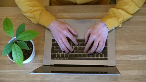 Pprogrammer in a yellow shirt typing code on the keyboard Stock Footage 142400885