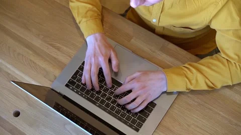 Pprogrammer in a yellow shirt typing code on the keyboard Stock Footage 142400968